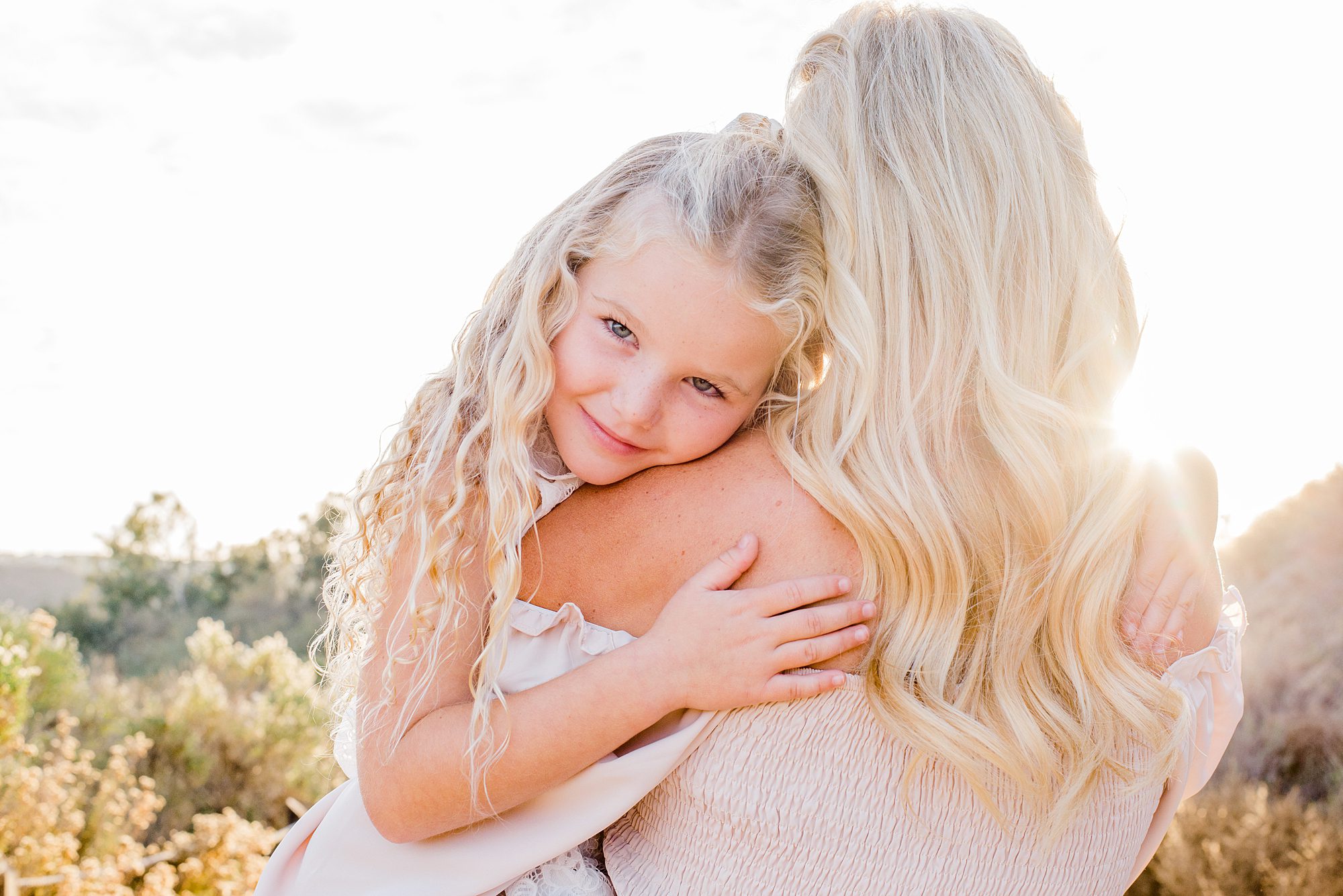 mom holds daughter during Carlsbad Sunset Family Session