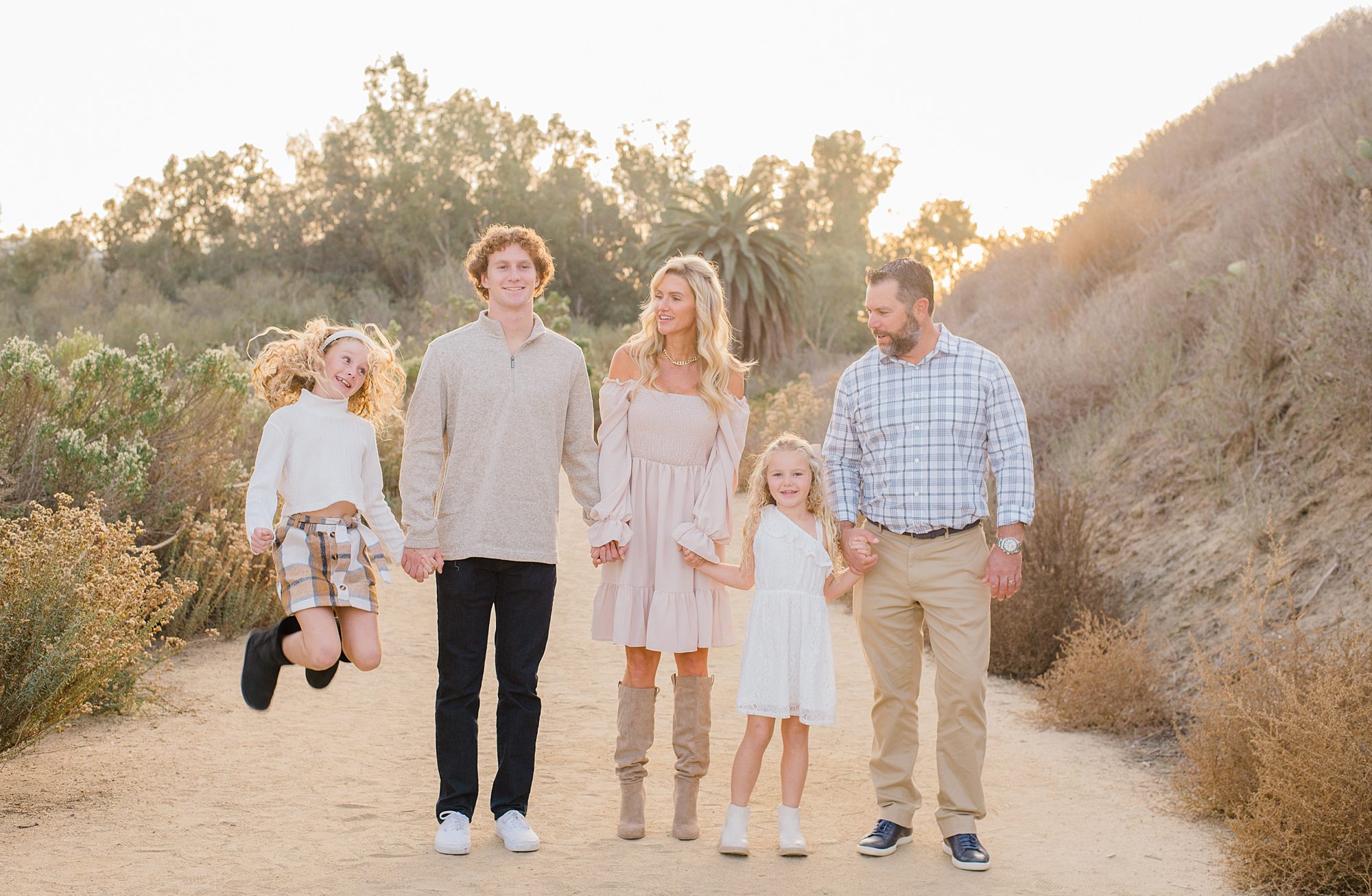 little girl jumps during family portraits in Carlsbad, CA