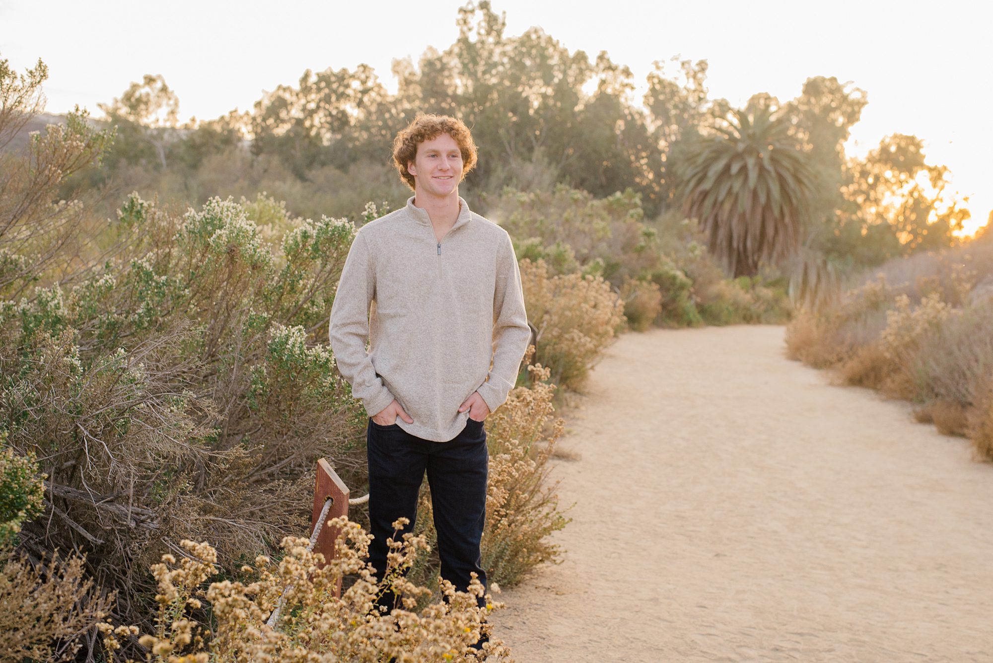 teenage boy stands on trail during family session 