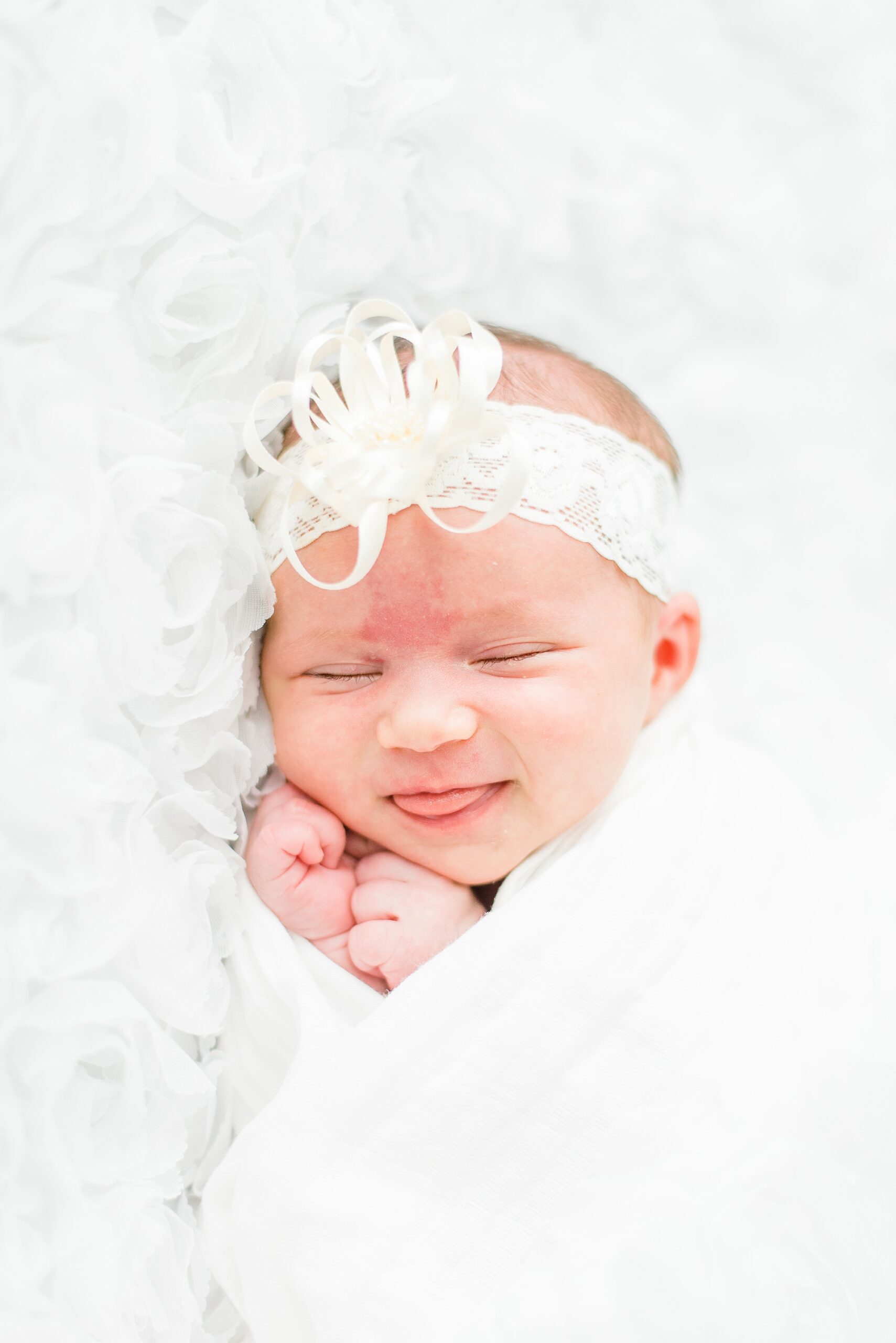 candid portrait of newborn girl sleeping and sticking out her tounge