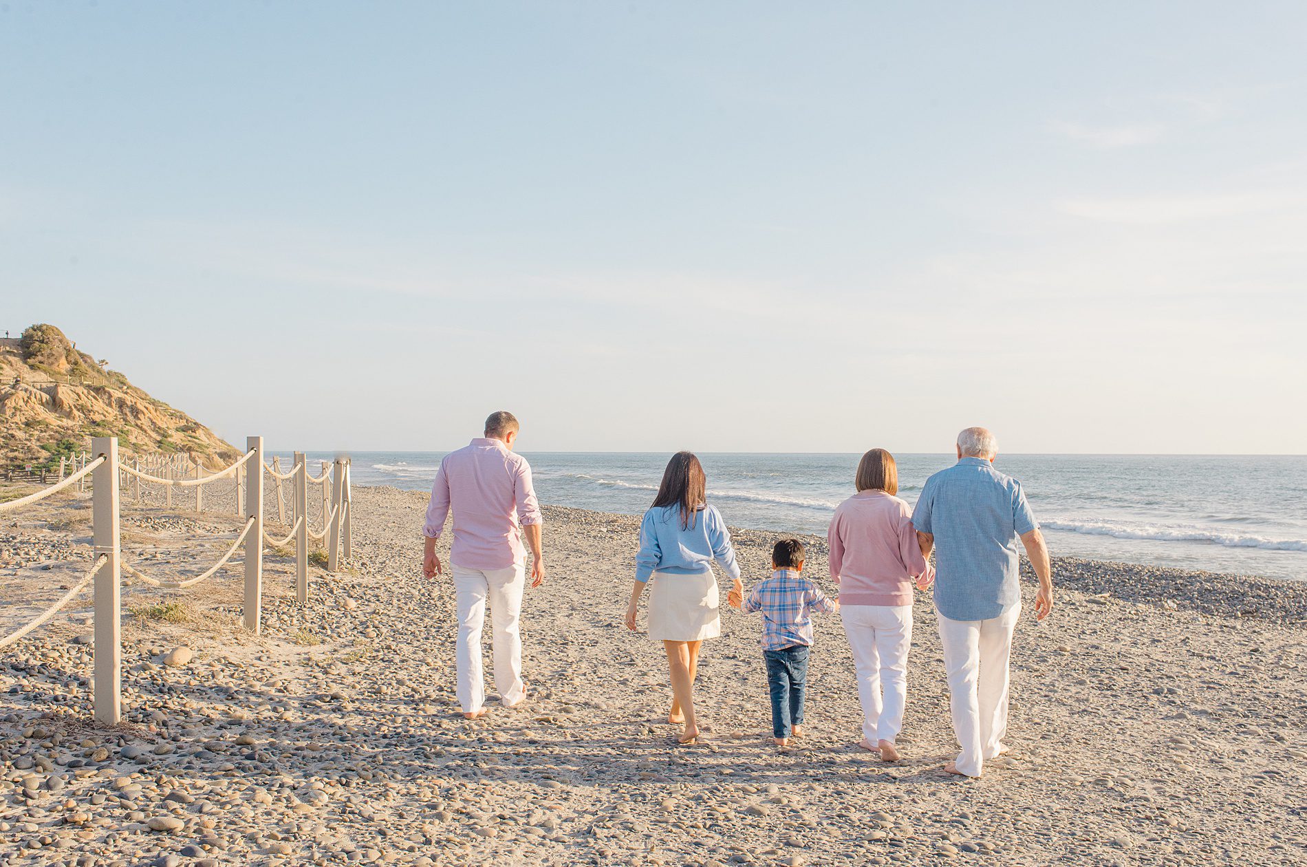 grandparents walk with their grandson and family during Coastal Family Portraits in Carlsbad California 