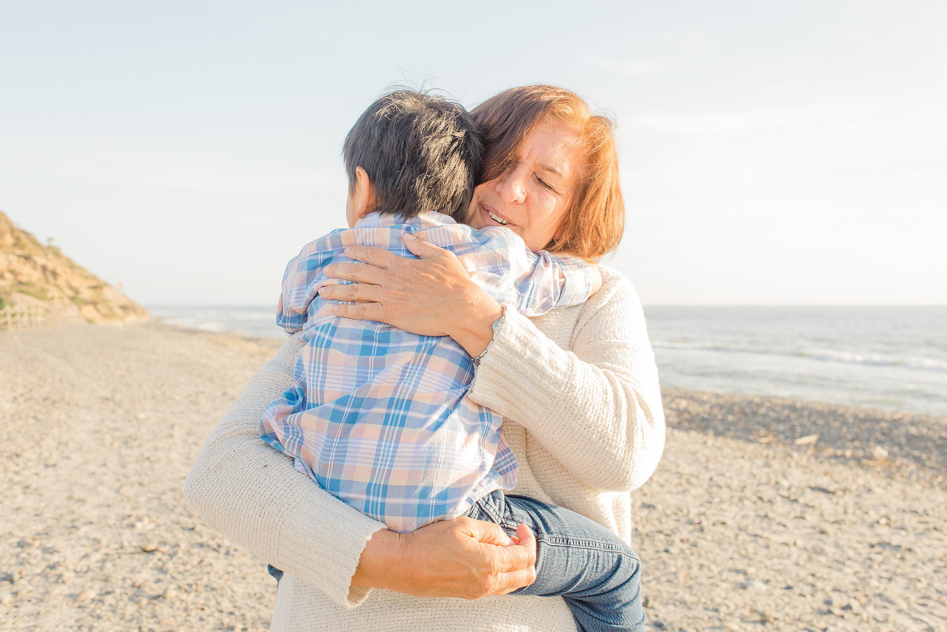 nanny hugs little boy during Coastal Family Portraits in Carlsbad California 