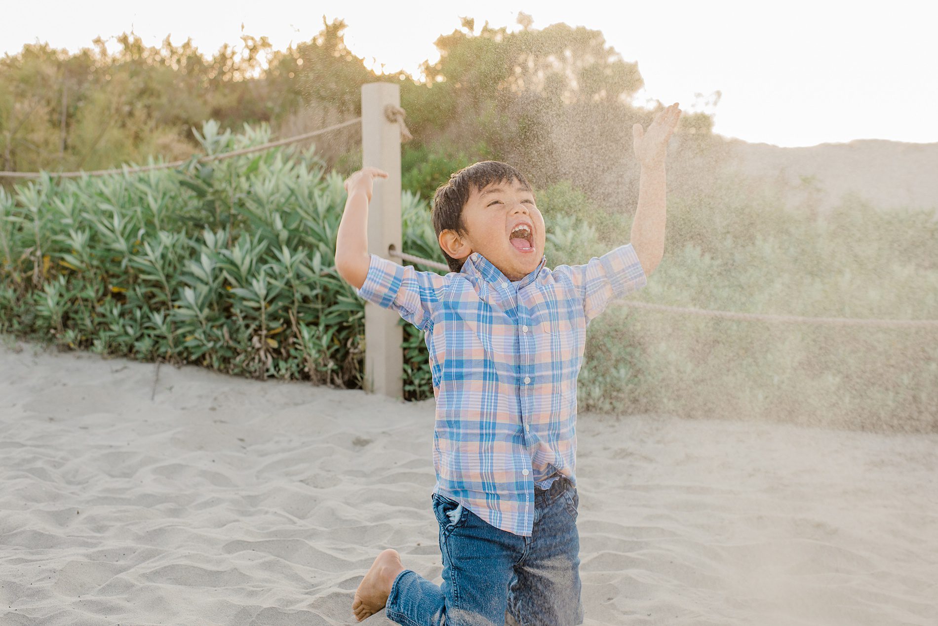 little boy plays in the sand during Coastal Family Portraits in Carlsbad California 
