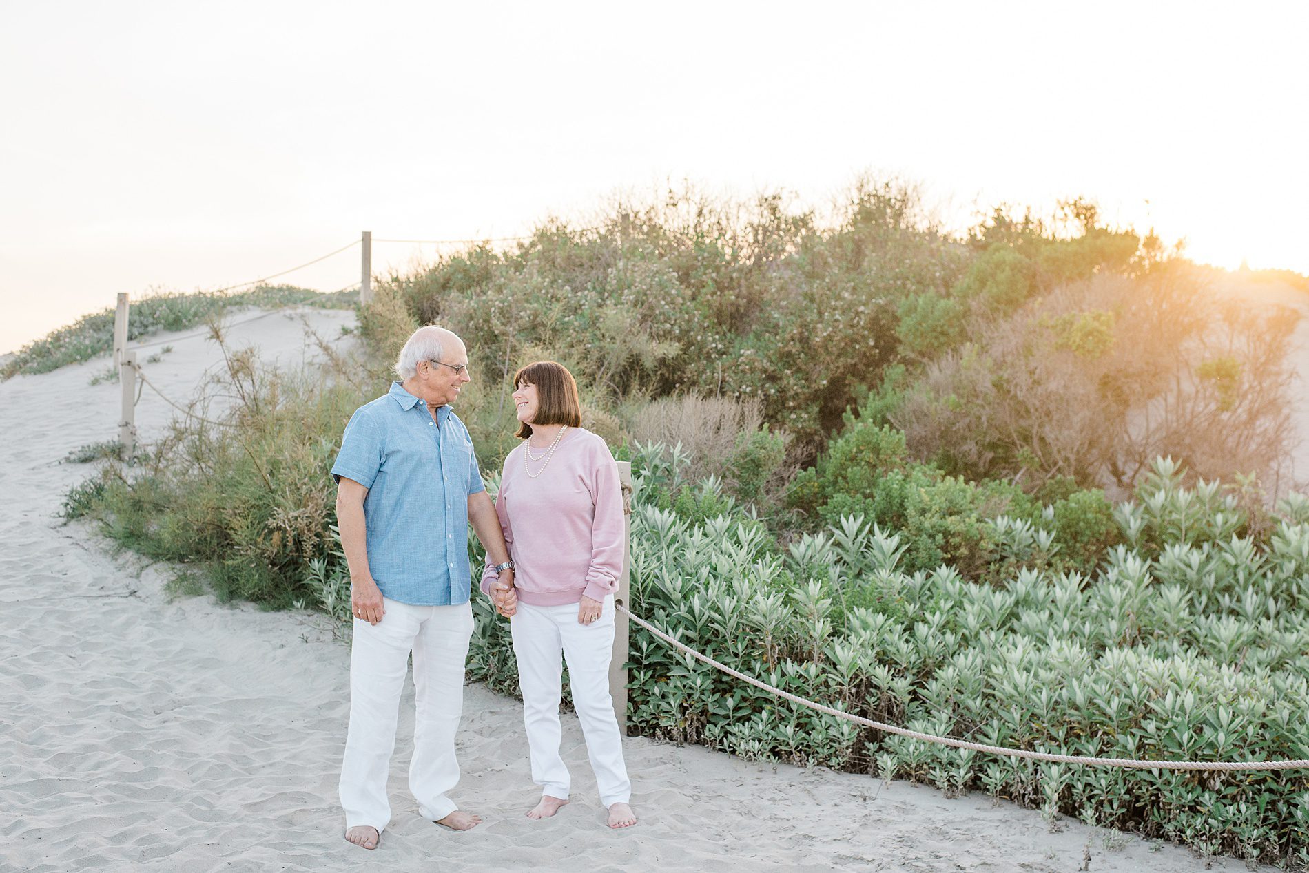 grandparents hold hands on beach during Coastal Family Portraits in Carlsbad California 