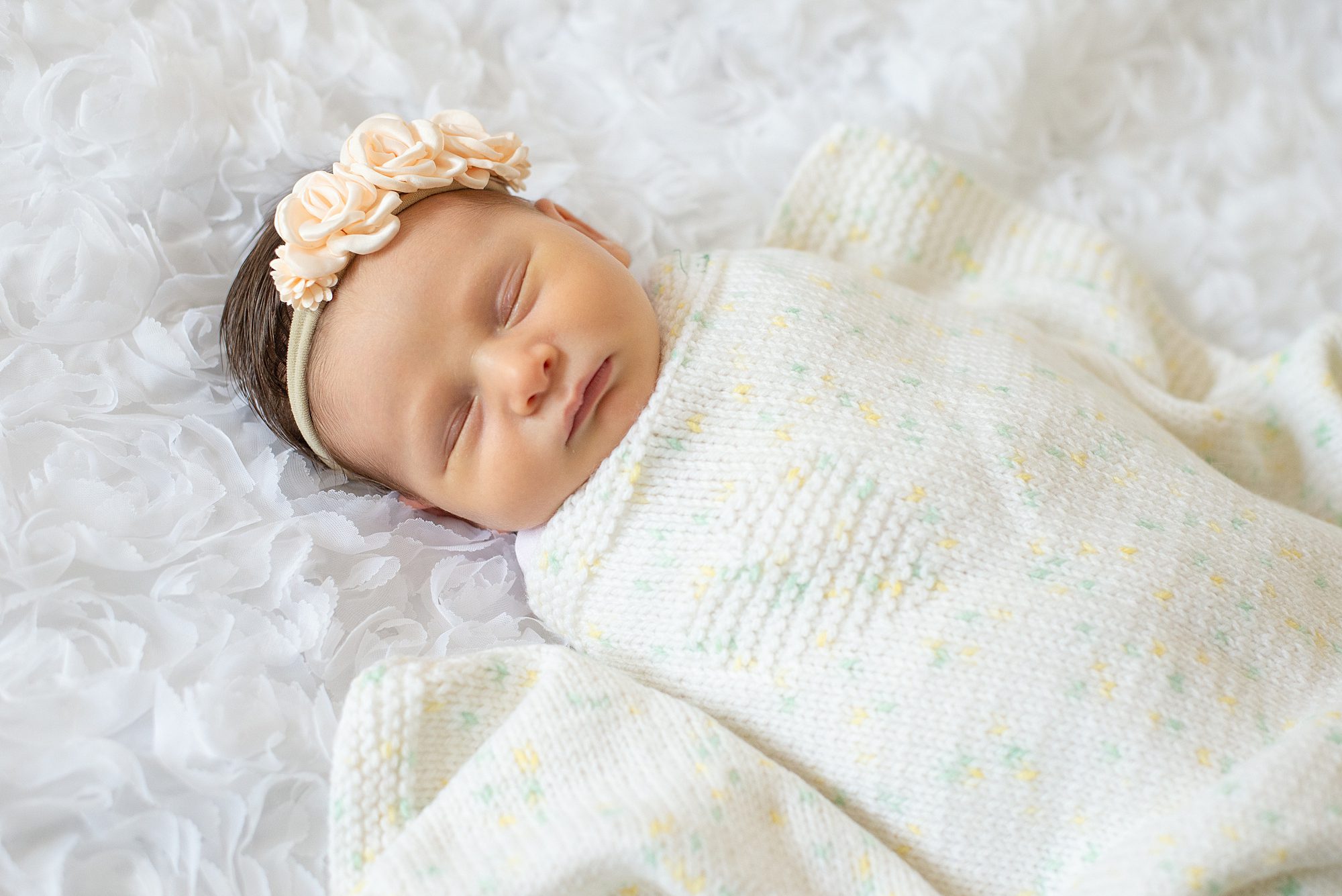 newborn girl sleeps swaddled in handmade blanket