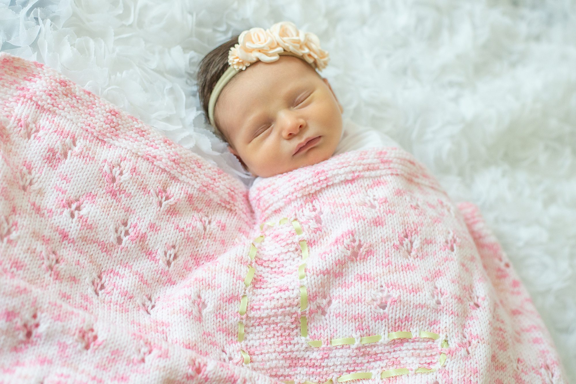 newborn girl wrapped in pink handmade blanket 