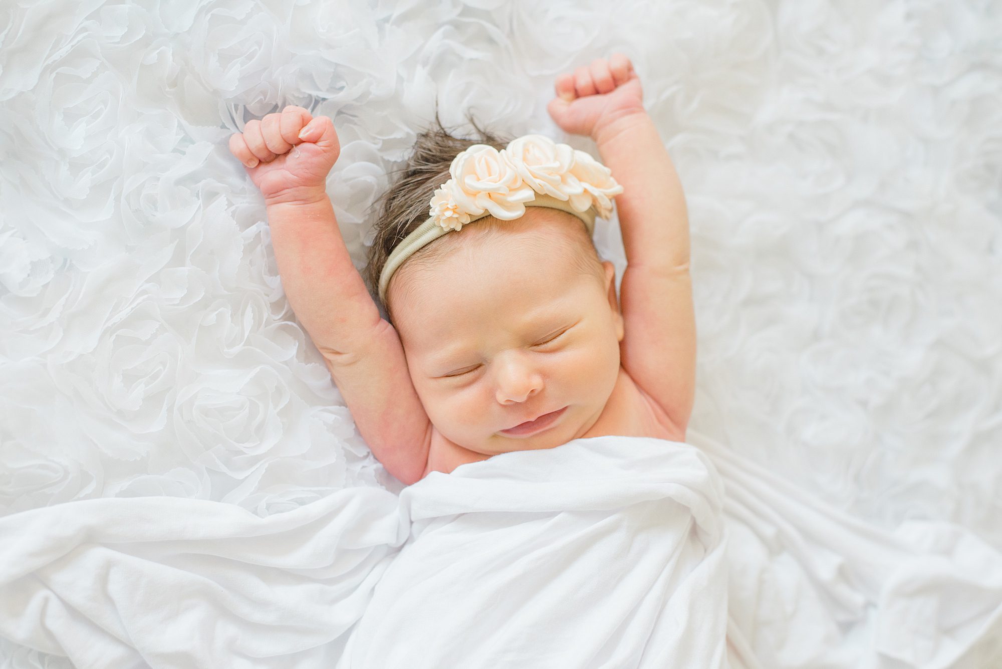newborn girl stretches out during in-home Timeless Newborn Portraits in San Marcos, CA