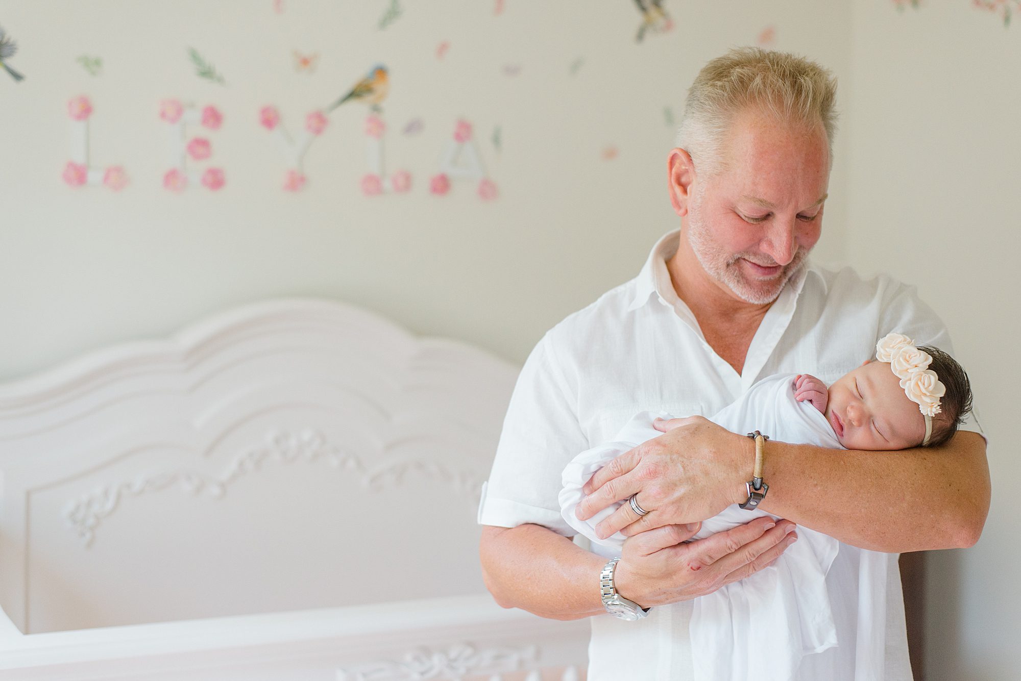 dad holds his daughter during in-home newborn portraits