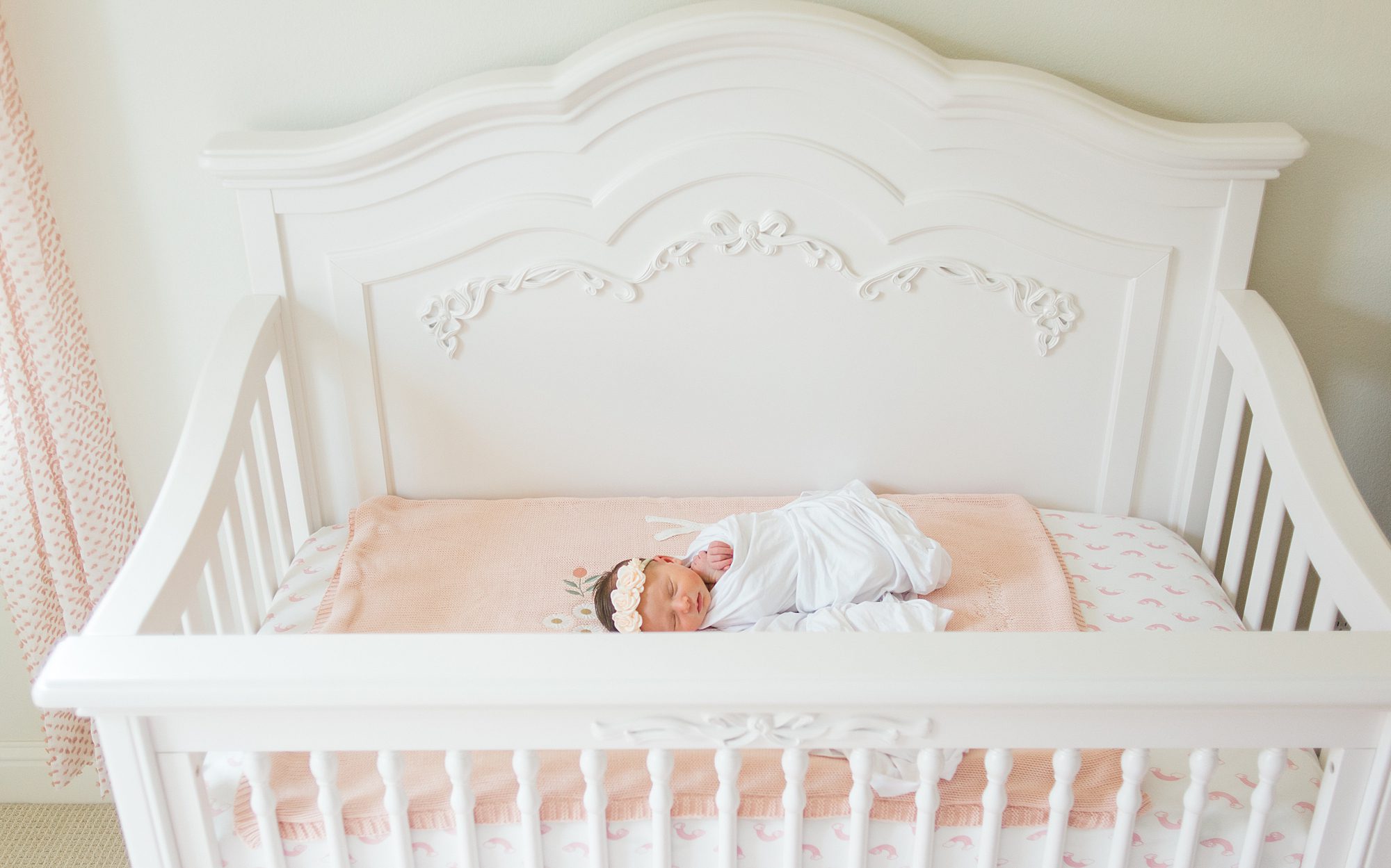 baby girl sleeps in her white crib