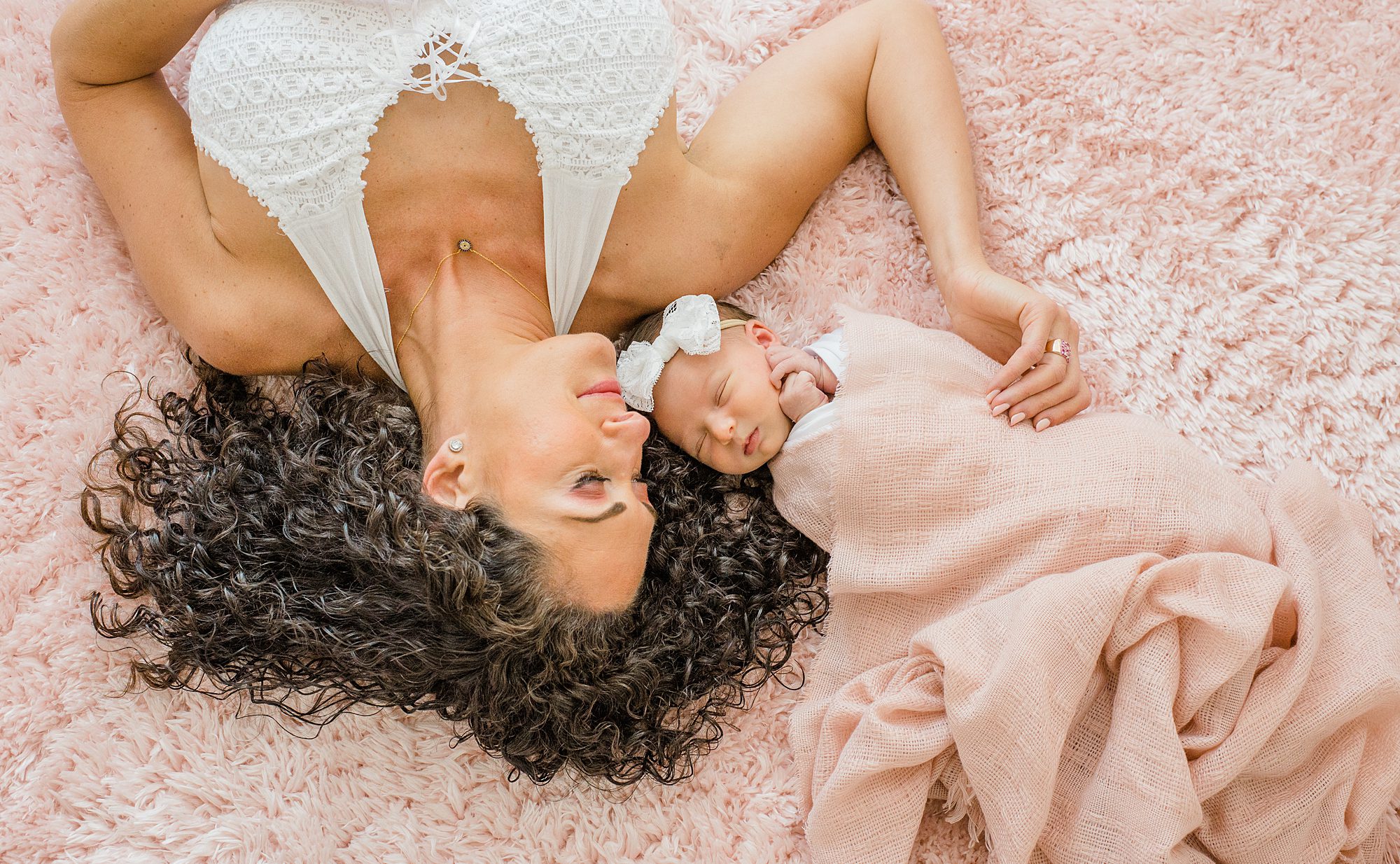 Timeless Newborn Portraits of mother laying next to her daughter 