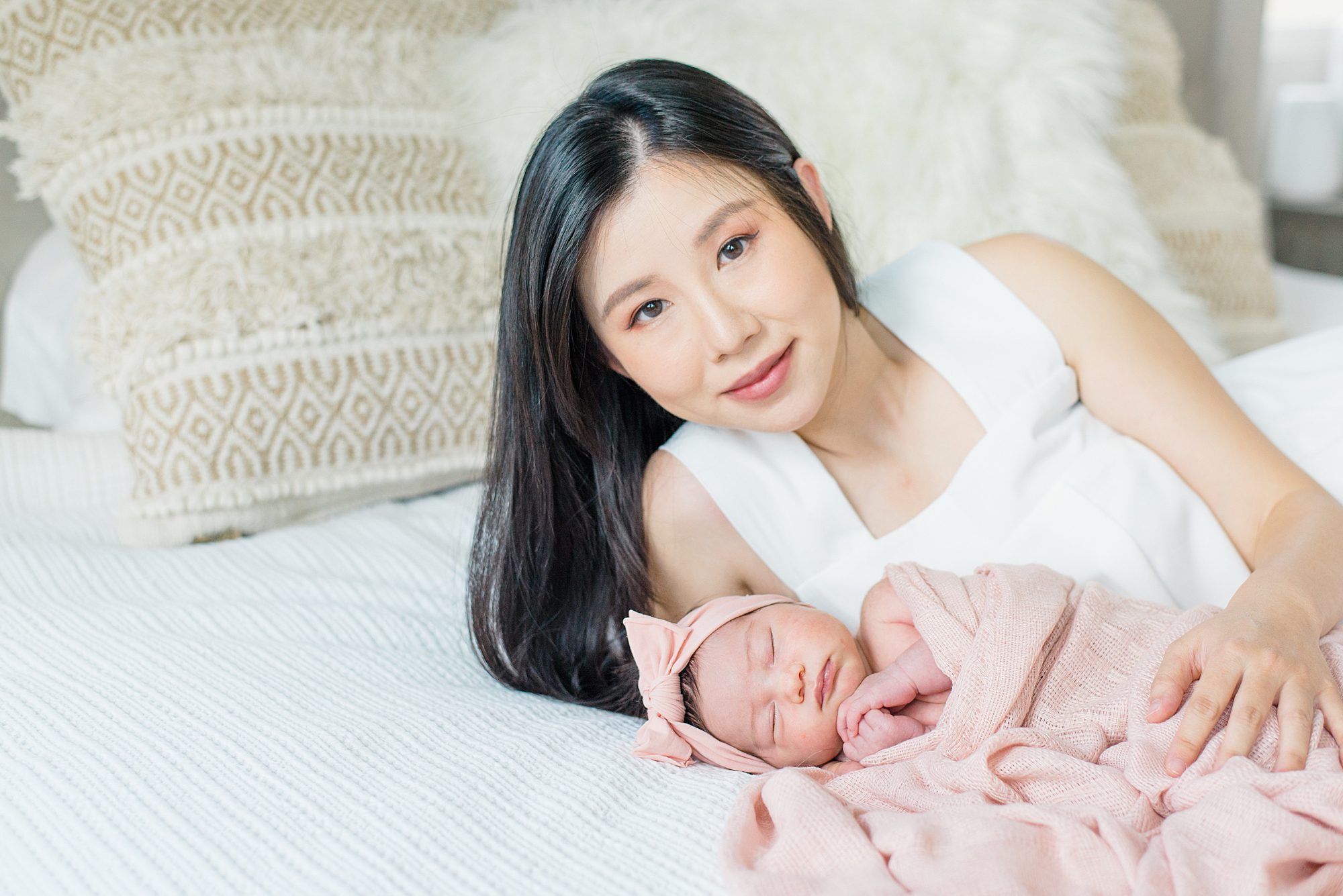 mom lays with her newborn girl on bed during Harmony Grove In-Home Newborn Session 
