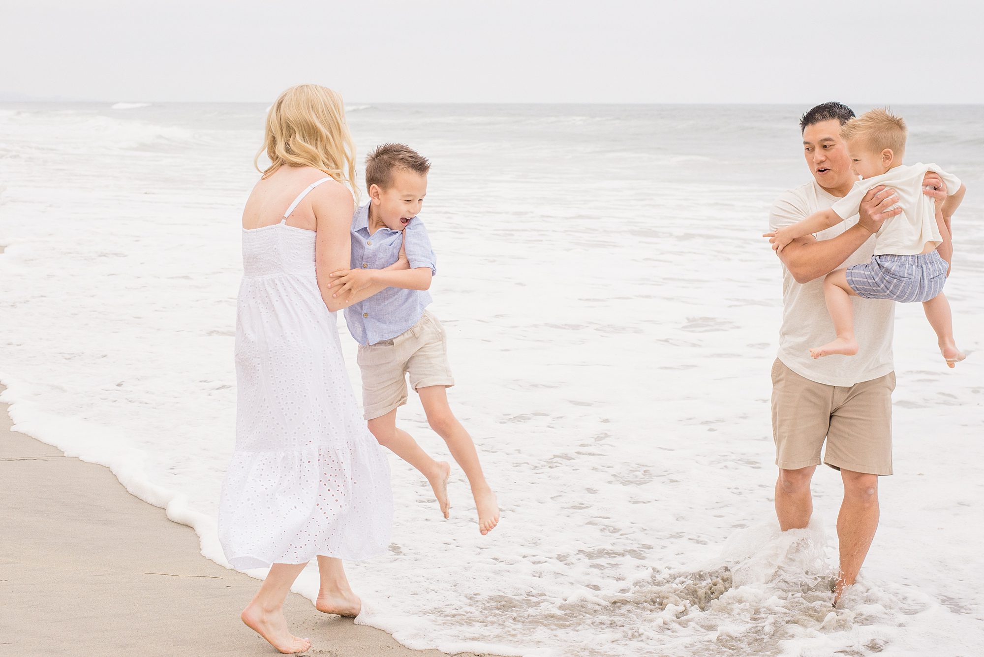Family splashes in the ocean during San Diego Family Beach Session