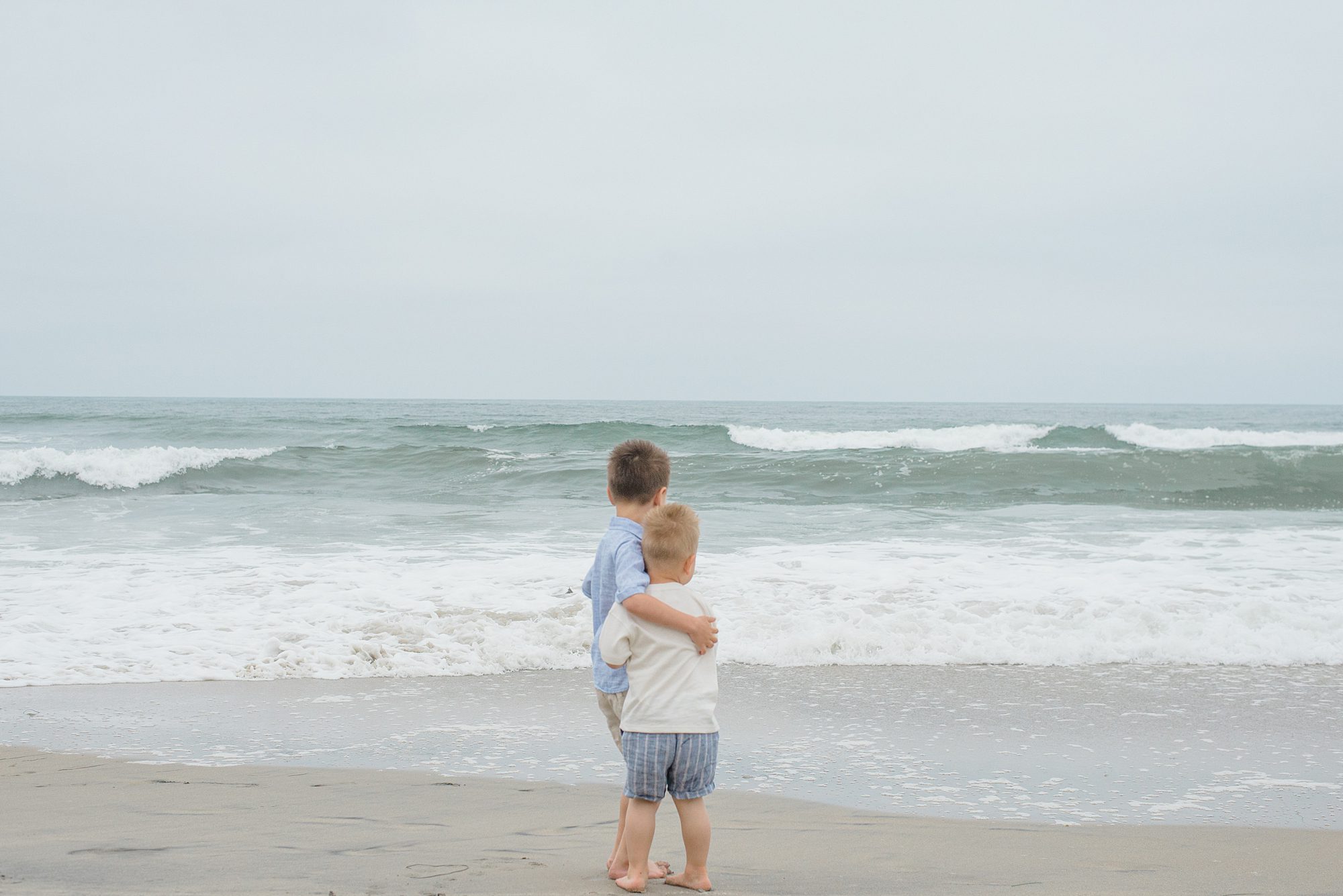 brothers watch the waves of the ocean during San Diego Family Beach Session