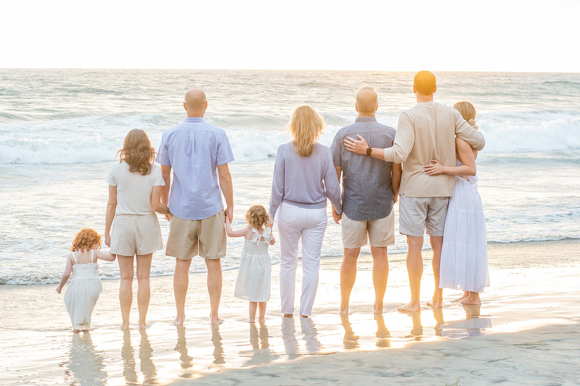 family holds hands on the beach in San Diego 