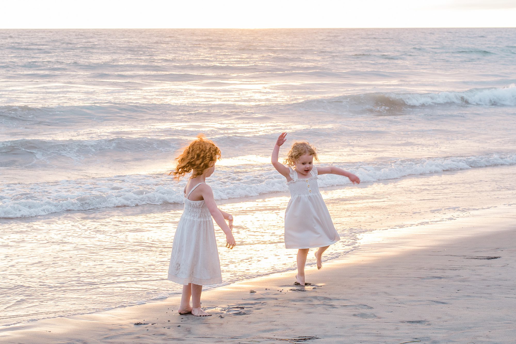 candid portraits of sisters dancing on the beach during Gorgeous Family Beach Session