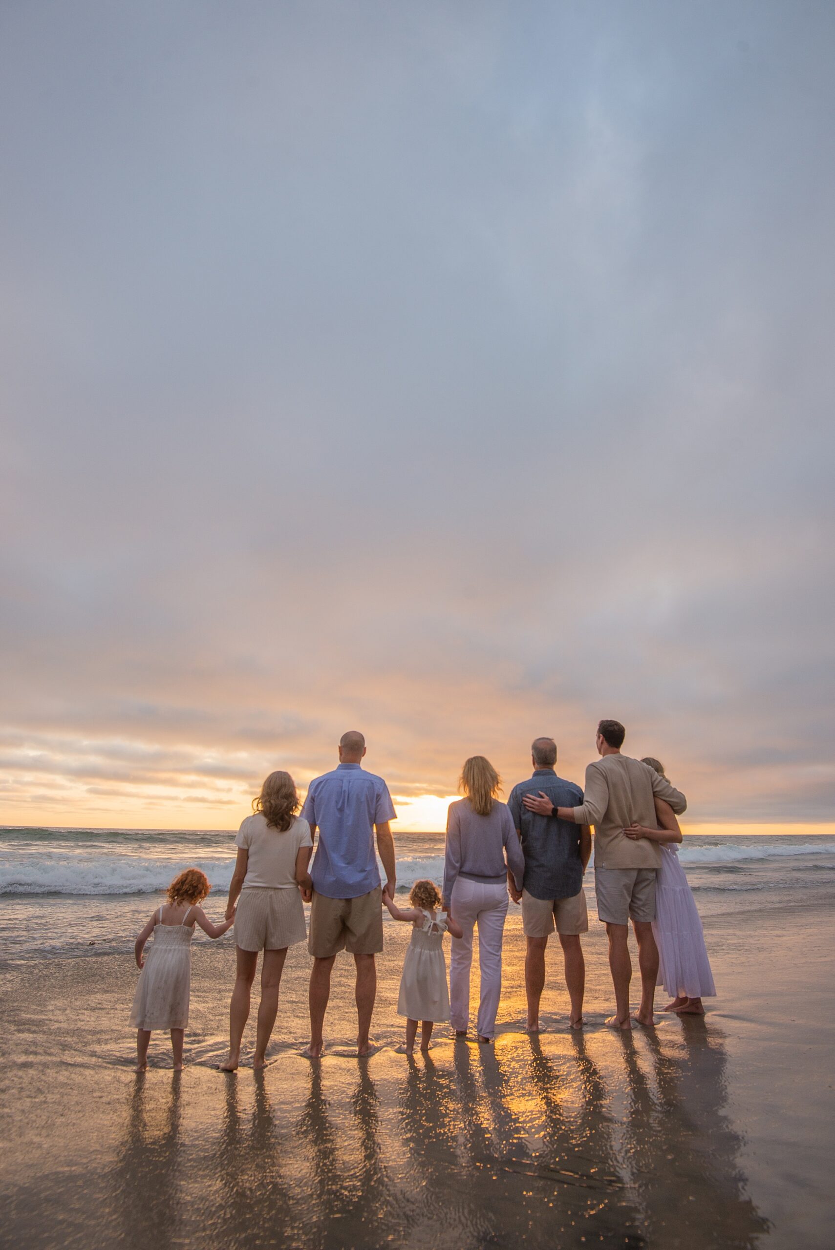 family of 8 looks out at the sunset during Gorgeous Family Beach Session