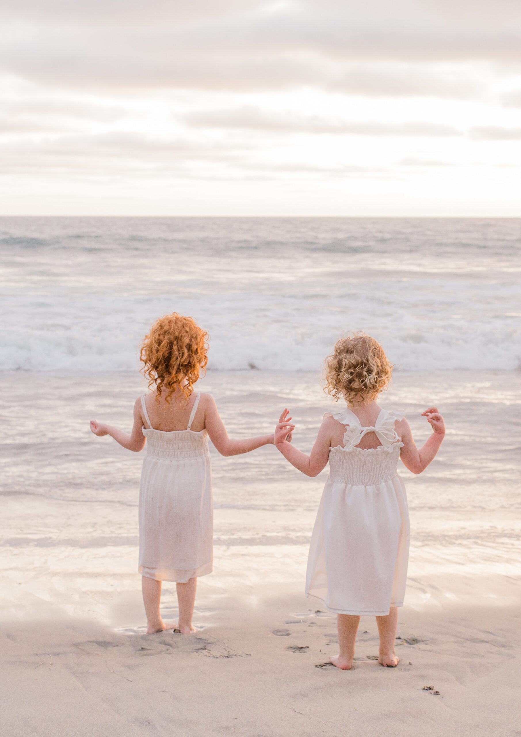 sisters look at the ocean during San Diego beach session