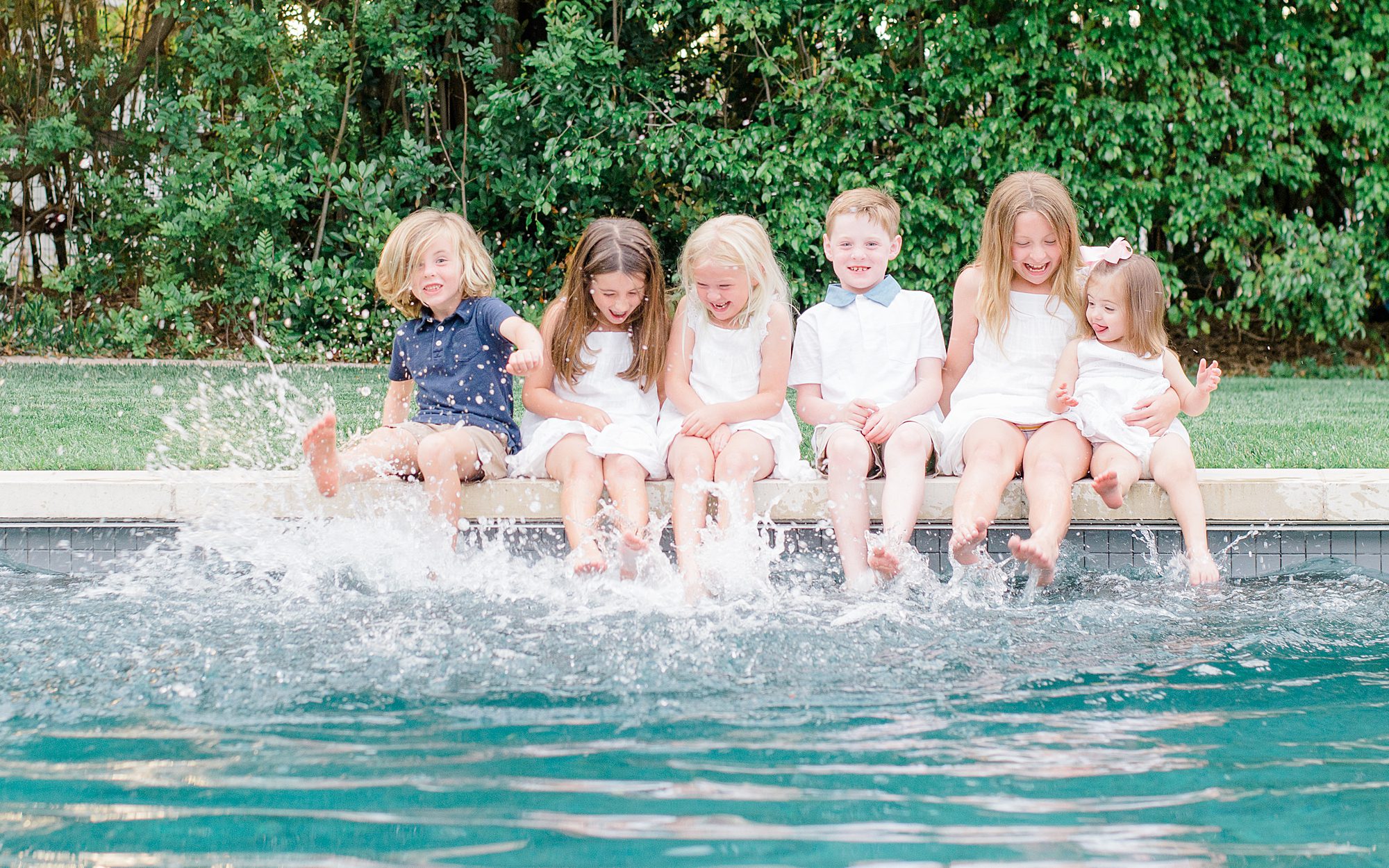 cousins sit and splash in the water