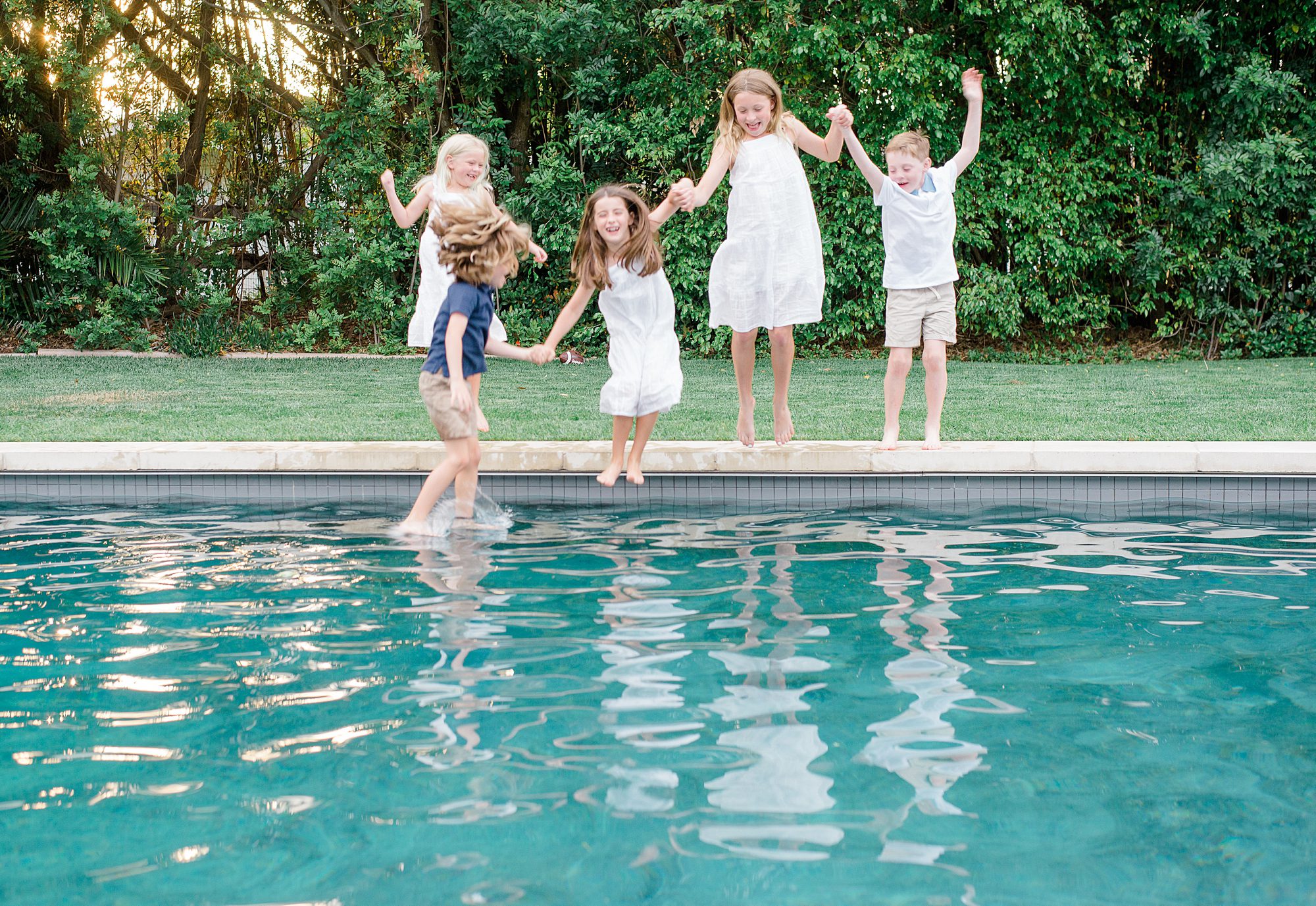 San Diego family photographer captures cousins jumping in the pool