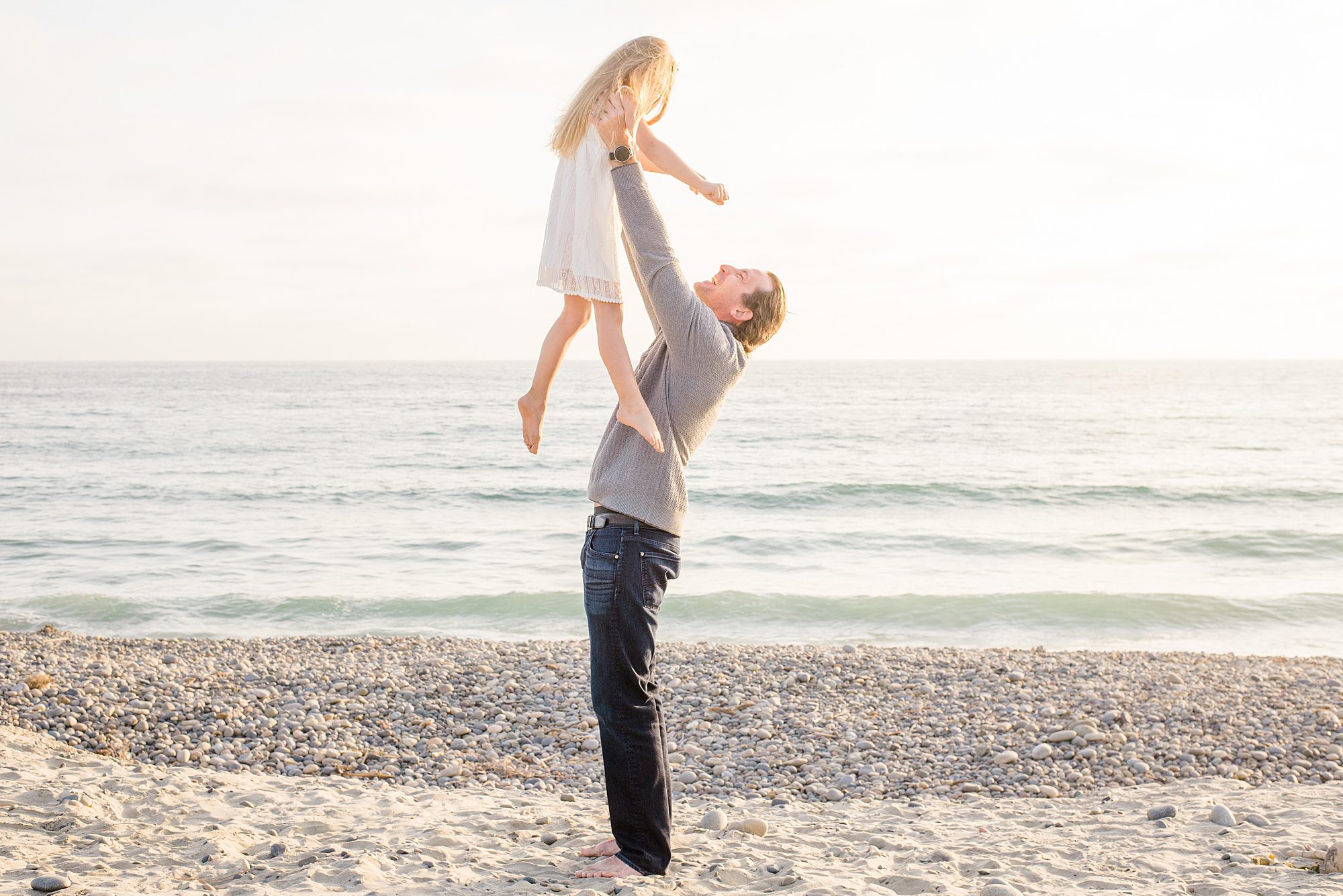 dad lifts his daughter up in the air 