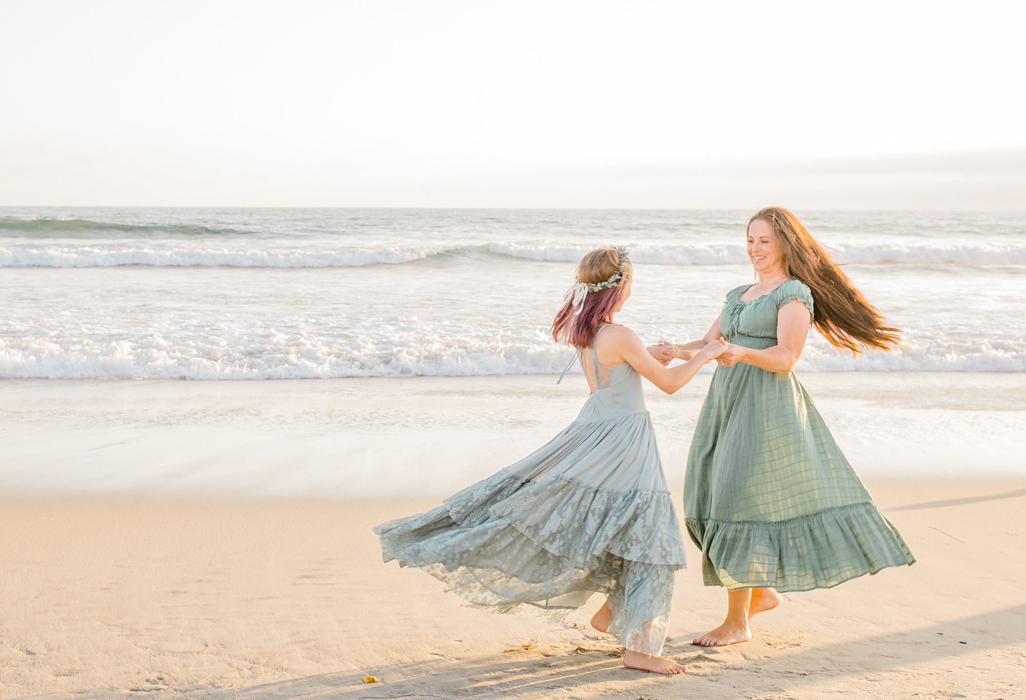 mother and daughter dance on the beach of Oceanside California 