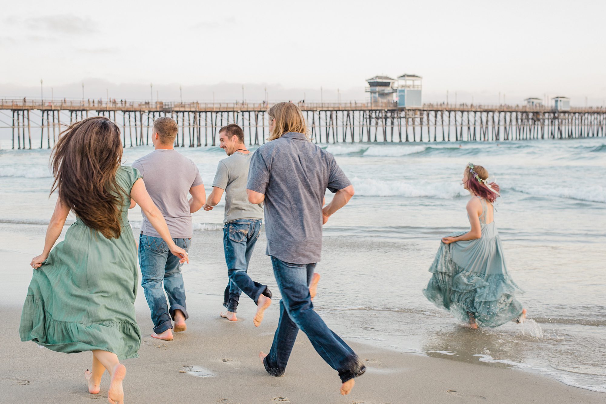 family runs along the beach