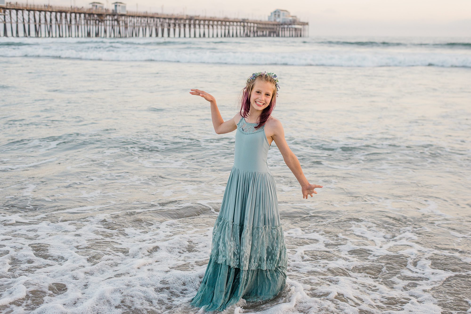 little girl stands on beach during family portraits