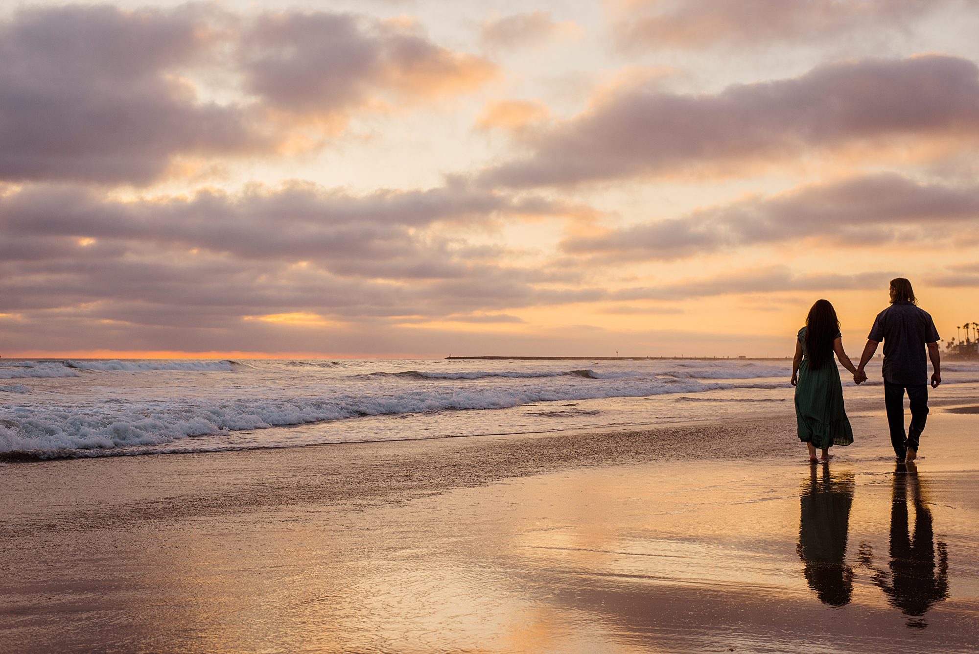 sunset portraits of husband and wife along the beach in Oceanside California 