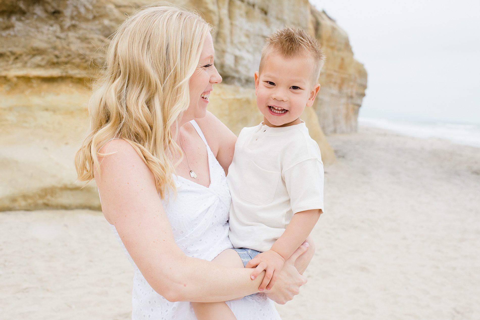 mom holds son in arms during San Diego Family Beach Session