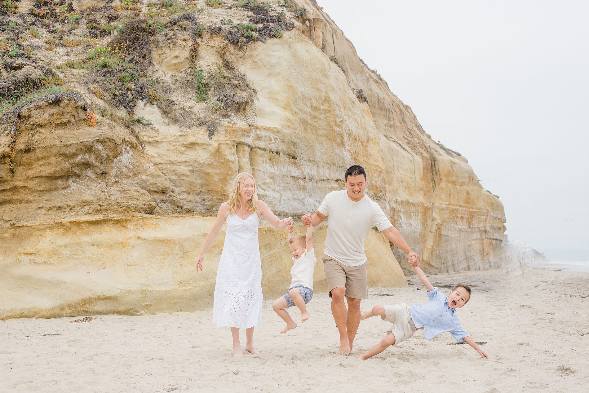 family of four walk the beach together in San Diego 