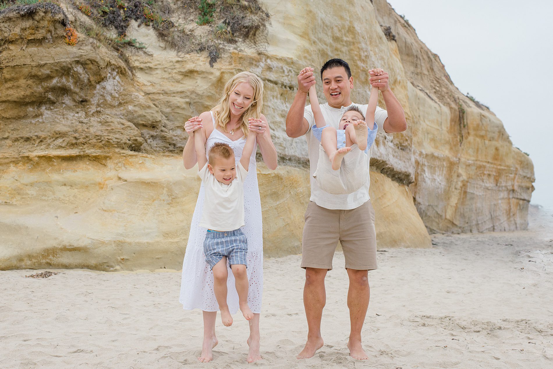 family of four have fun on the beach during San Diego Family Session photographed by San Diego family photographer Leigh Castelli 