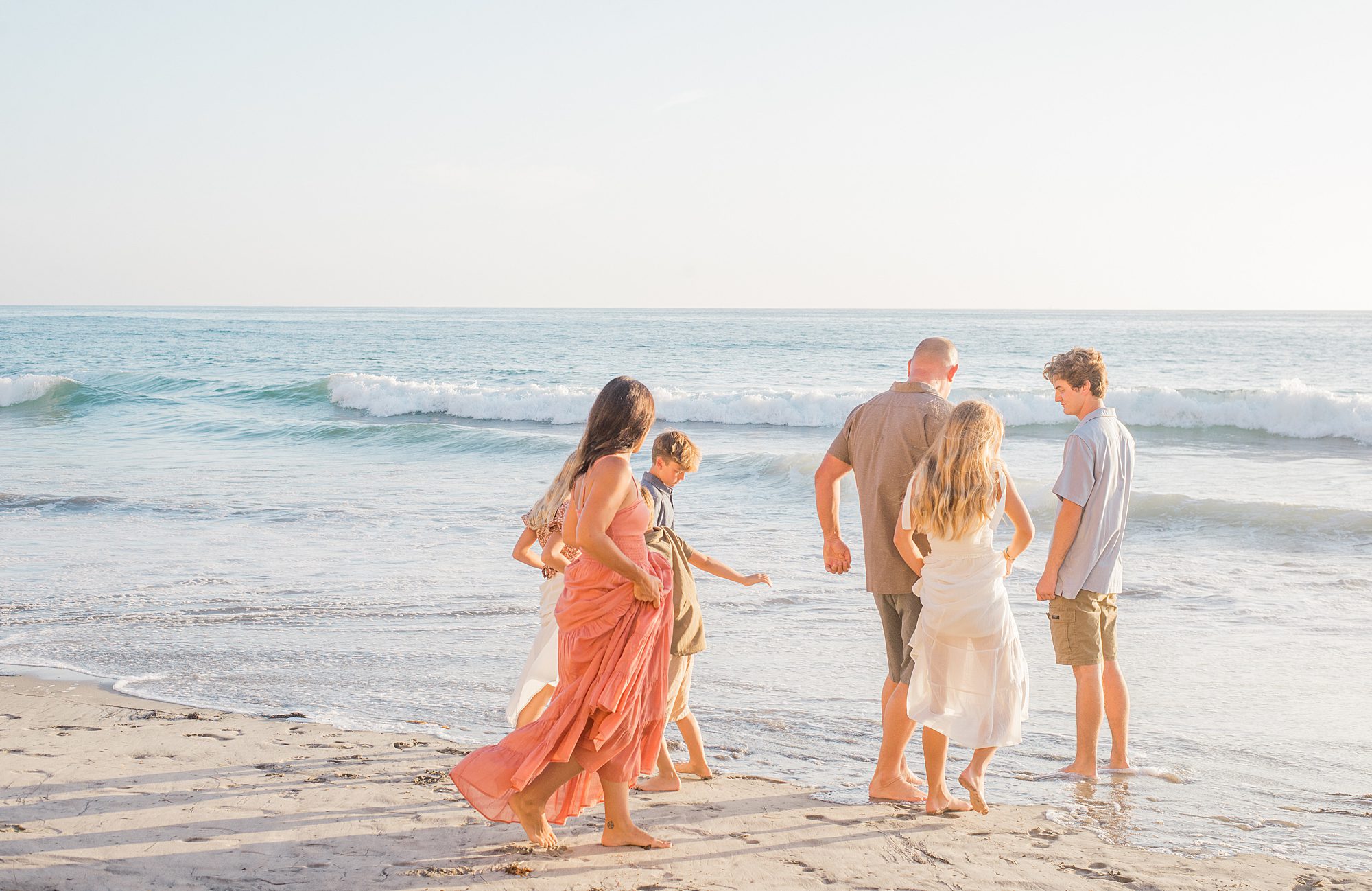 family walks into ocean during Solana Beach Family Session