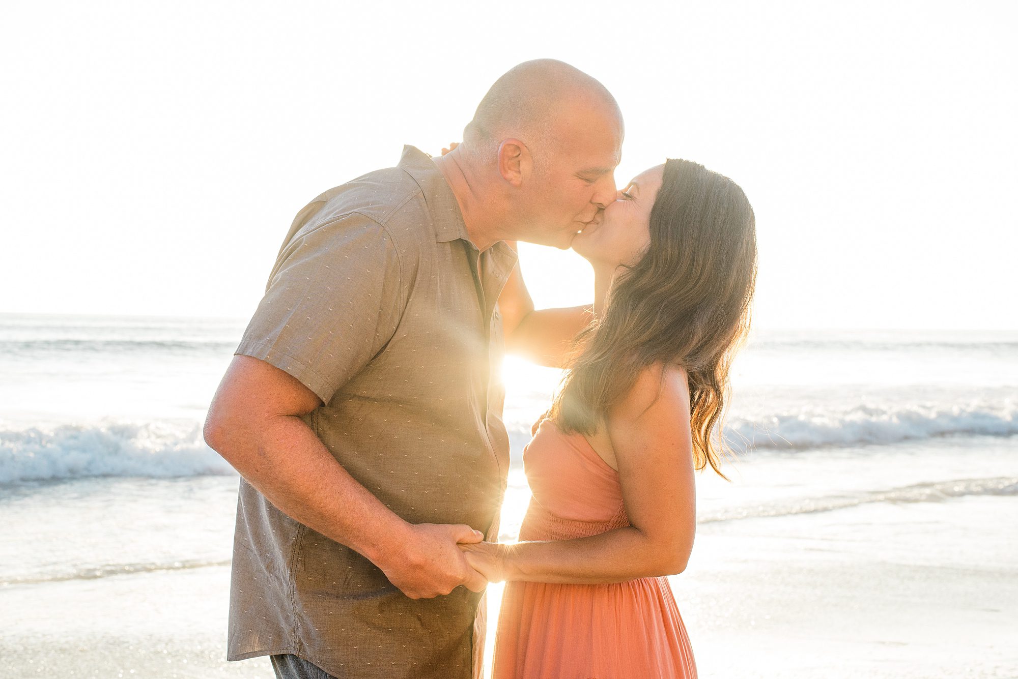 couple kiss on the beach during sunset for Solana Beach Family Session