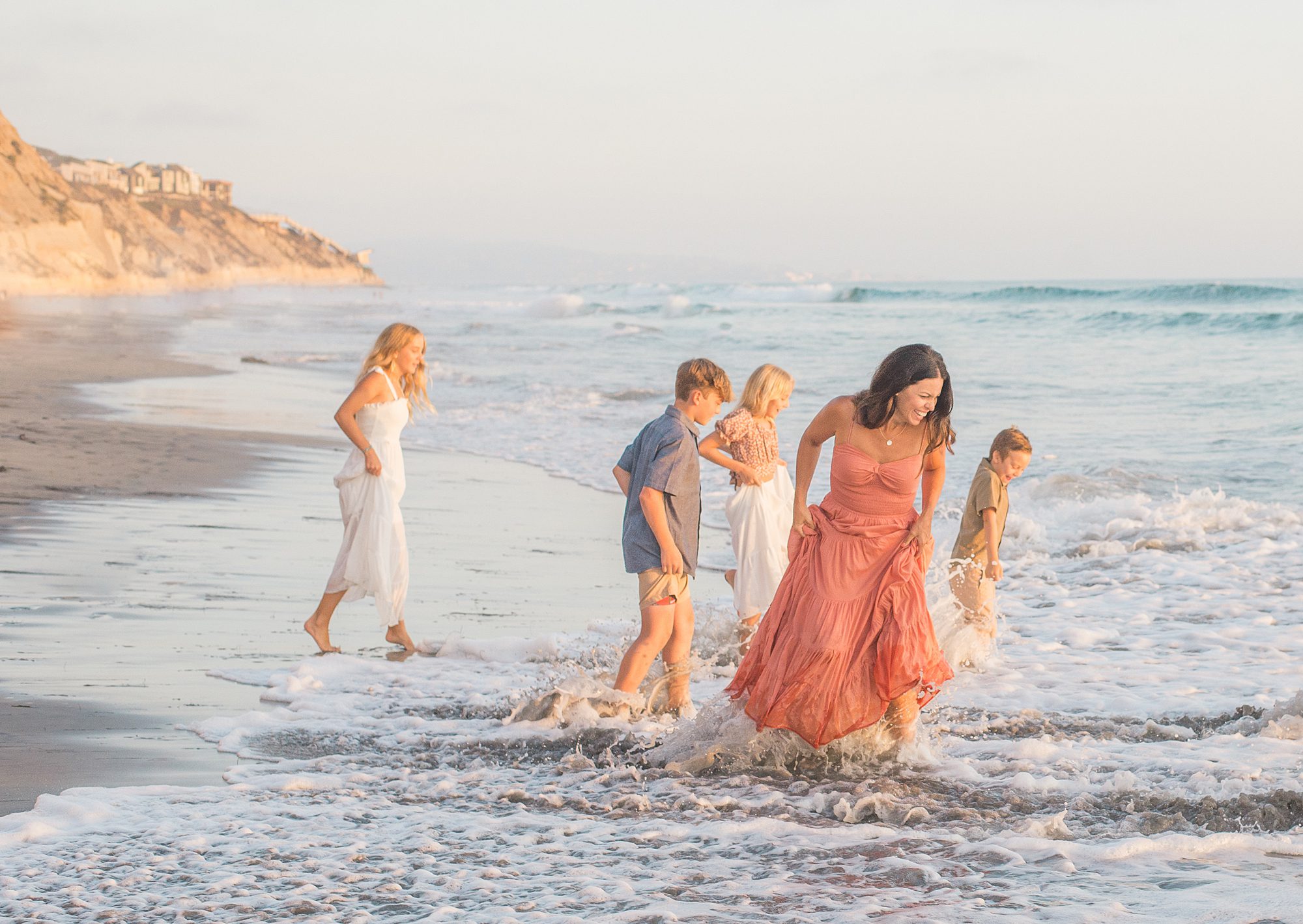 family plays in ocean waves from Solana Beach Family Session