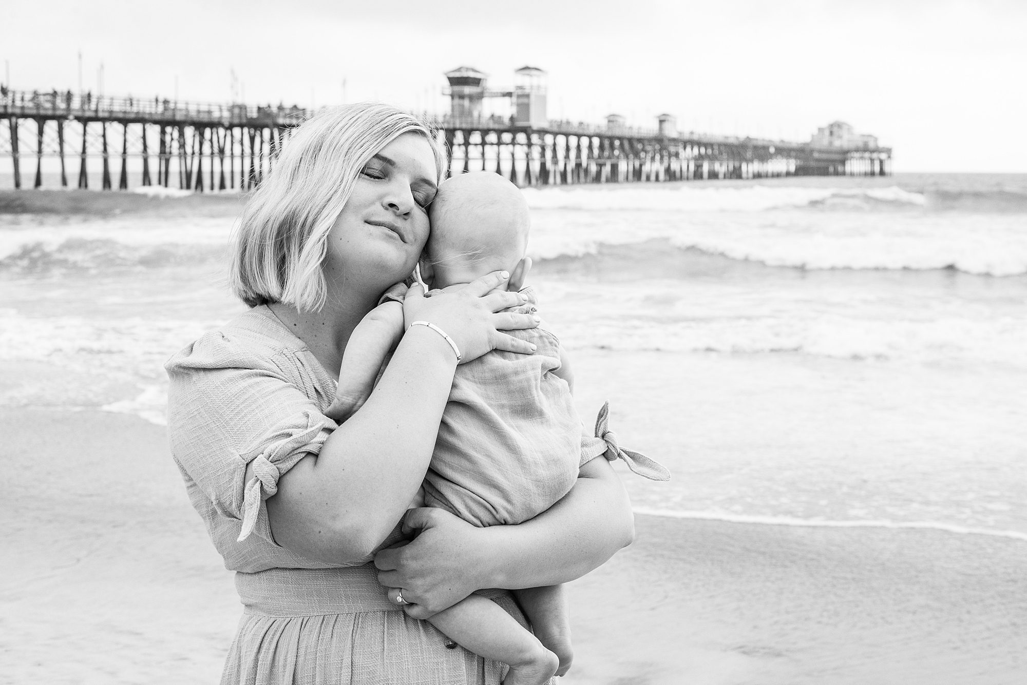 mom holds baby at beach session