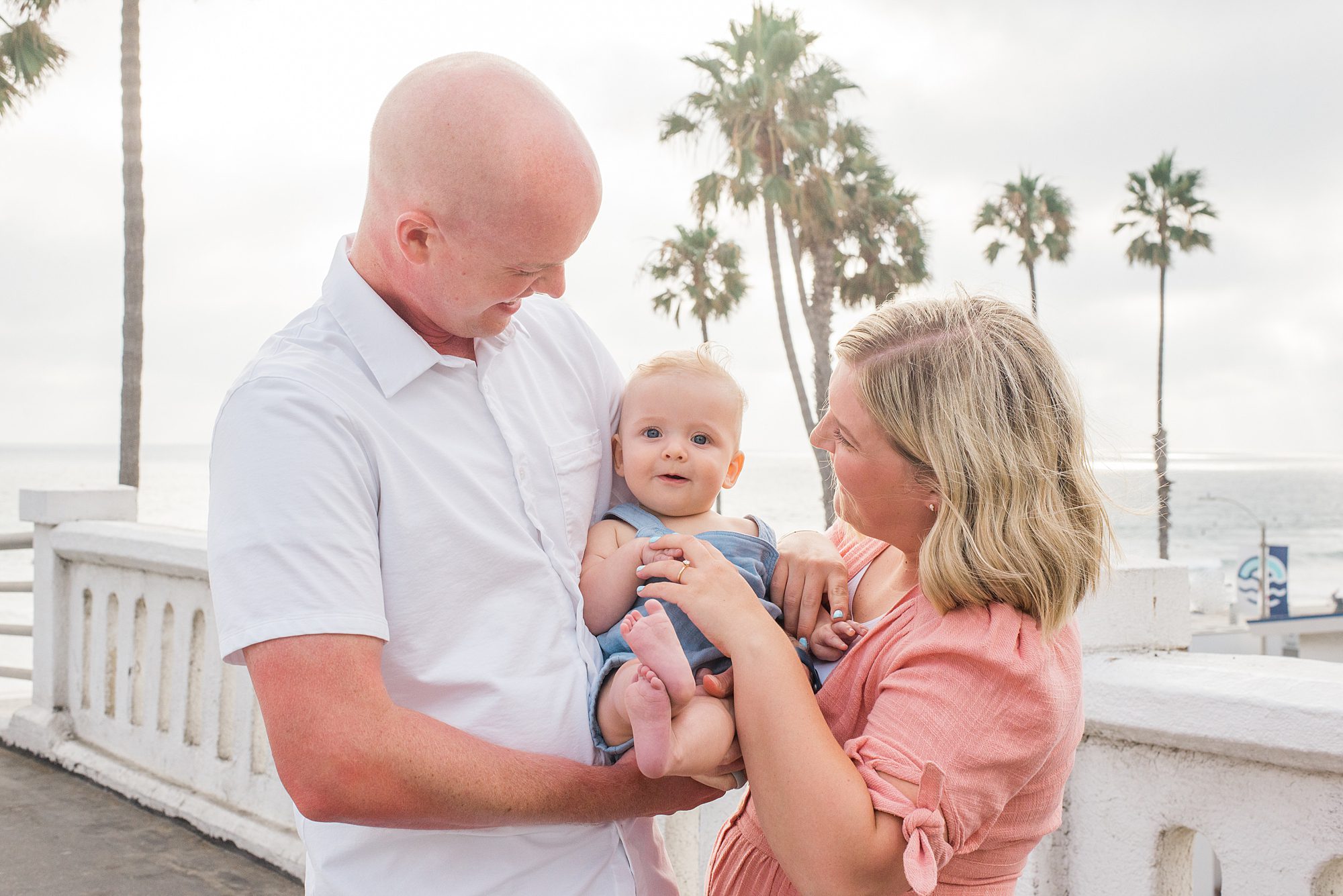 parents hold baby during Extended Family Sunset Session in Oceanside, CA 