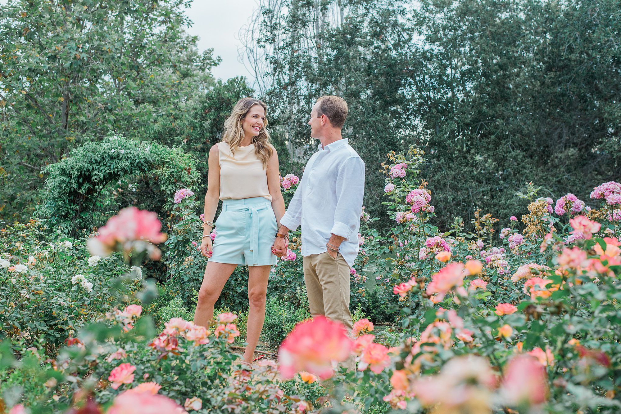 husband and wife walk through colorful garden in Carlsbad, CA