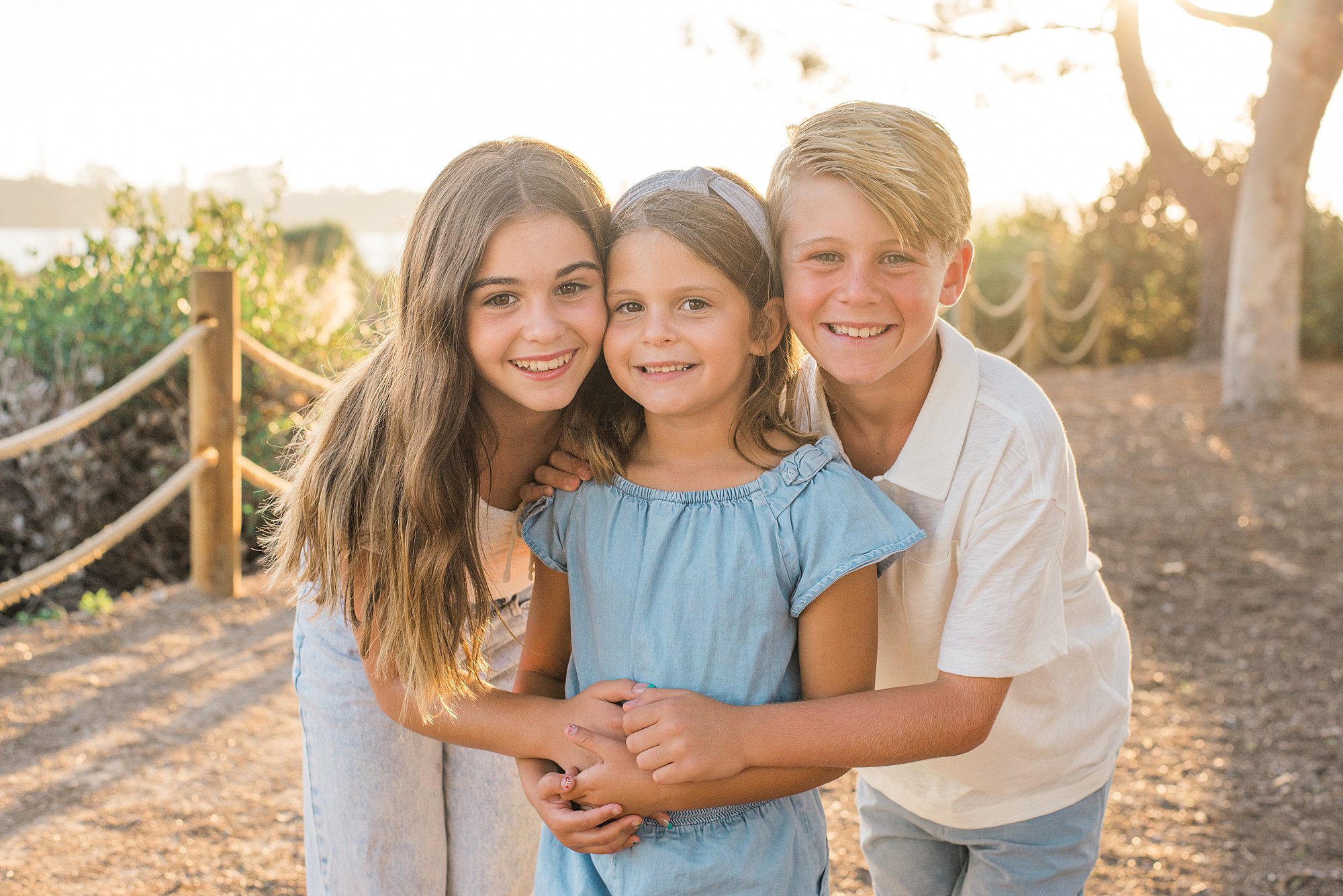 three siblings hug during family photos
