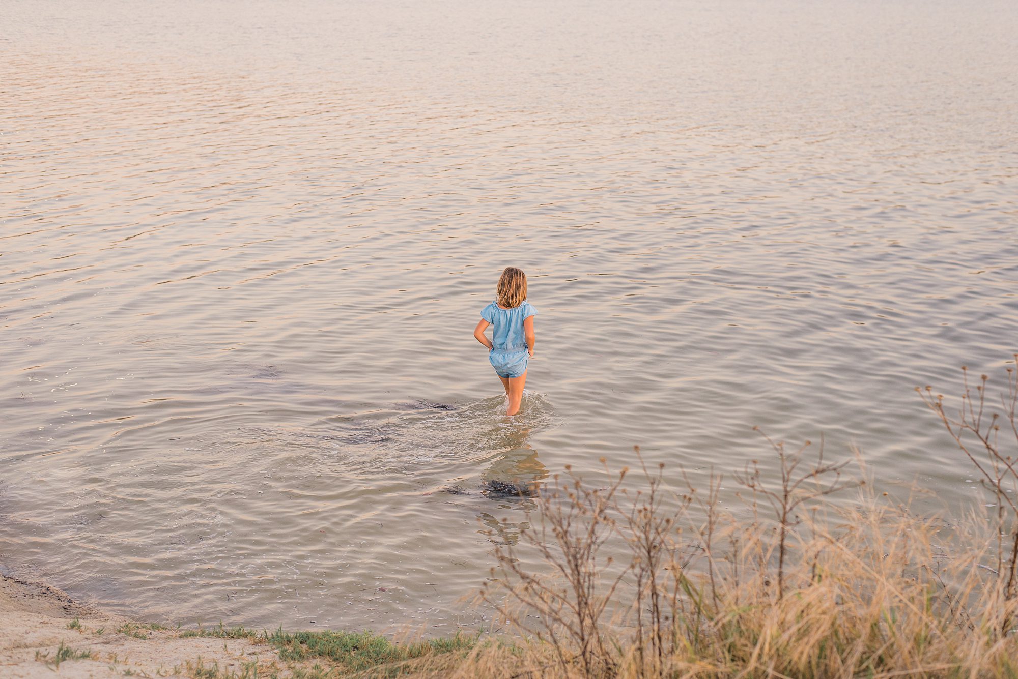 little girl walks into the water