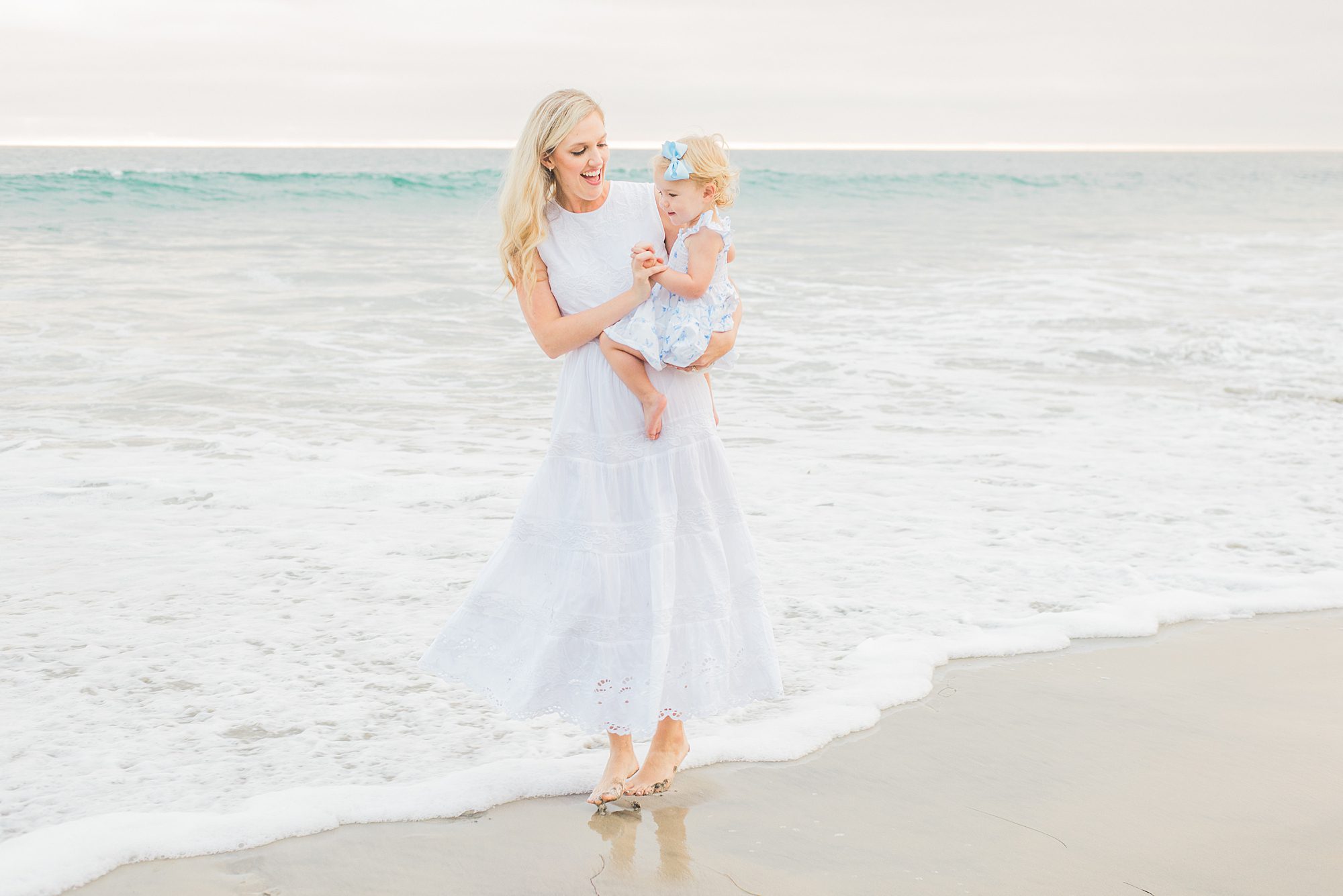 mom walks along Del Mar Beach with daughter