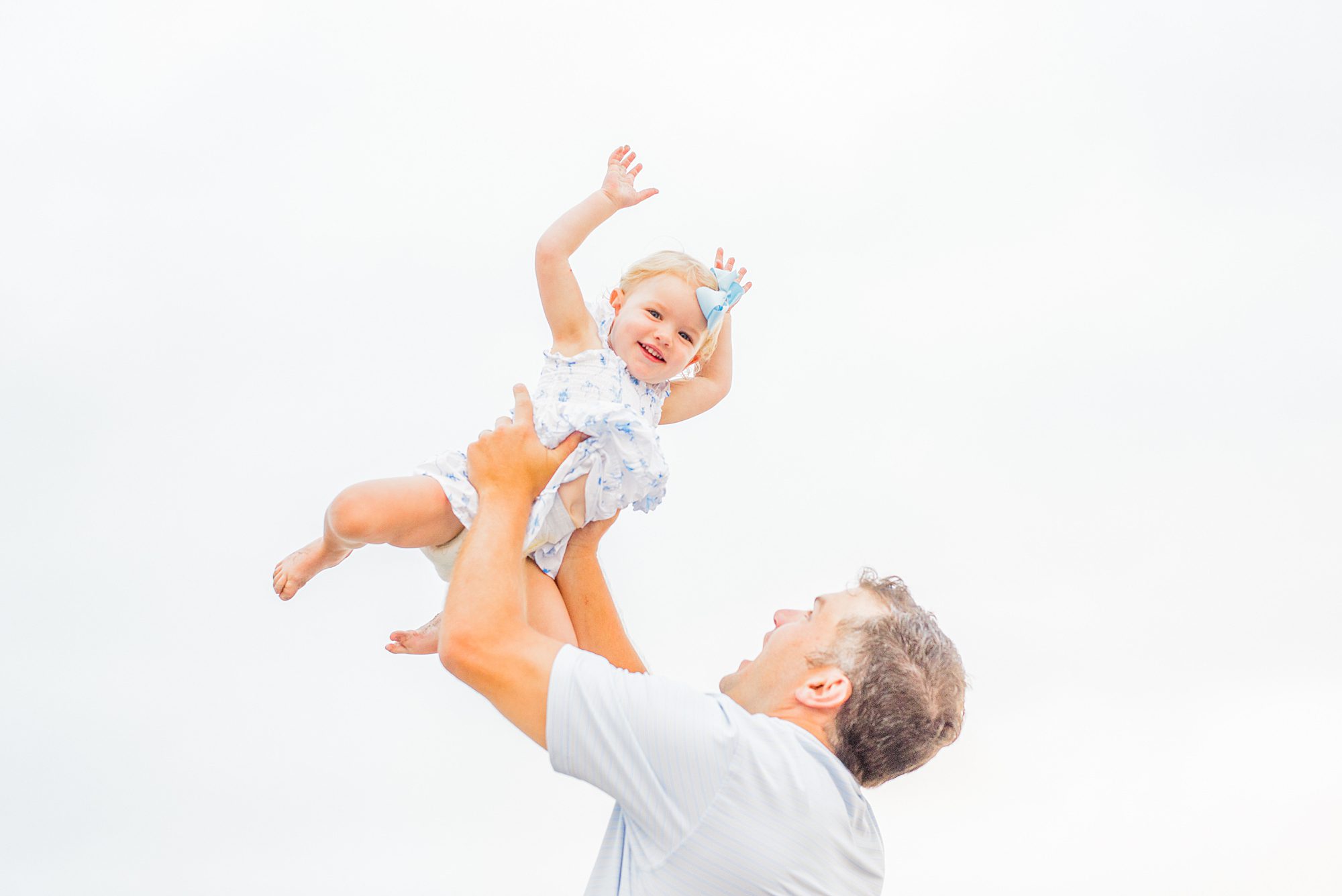 dad lits little girl up overhead