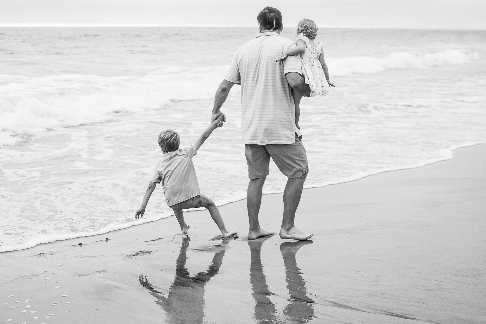 dad walks along Del Mar Beach with his kids