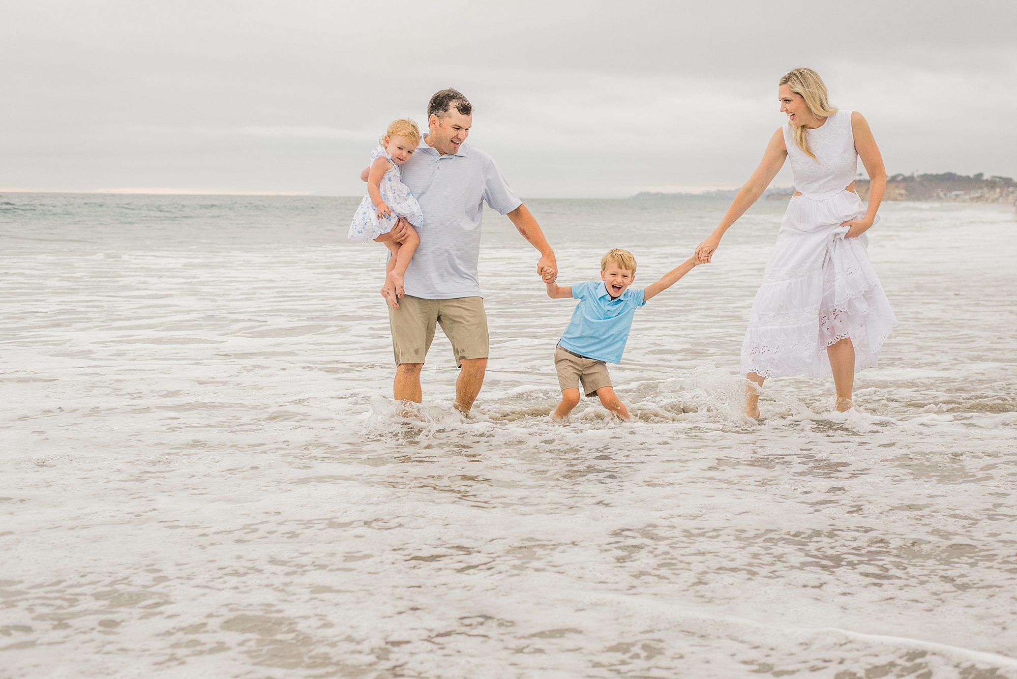 family has fun in the ocean waves during Del Mar Beach Family Session